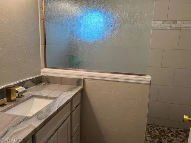Bathroom featuring vanity and tiled shower