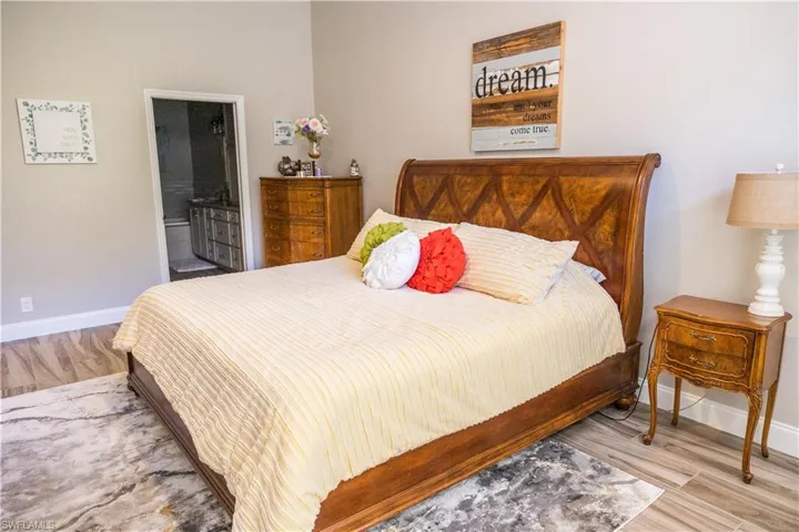 Bedroom featuring ensuite bathroom and light hardwood / wood-style flooring