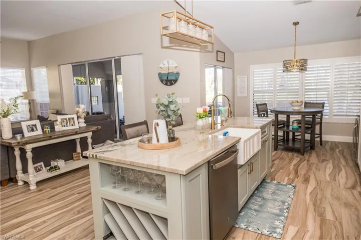 Kitchen with pendant lighting, stainless steel dishwasher, sink, and a kitchen island with sink