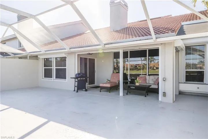 Rear view of property featuring a patio and glass enclosure