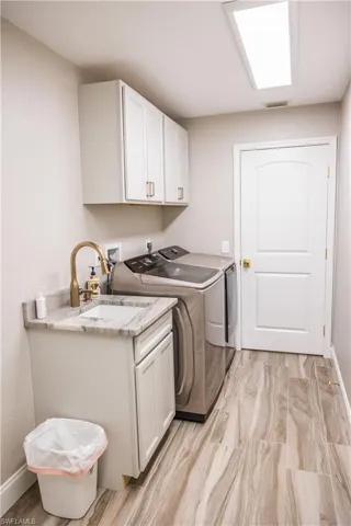 Washroom with cabinets, sink, and independent washer and dryer