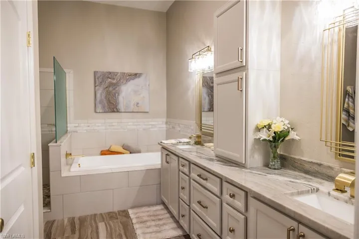 Bathroom featuring a relaxing tiled tub and vanity
