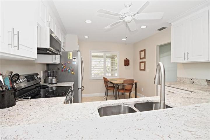 Full view of kitchen shows off lighting, crown molding cozy eating area.