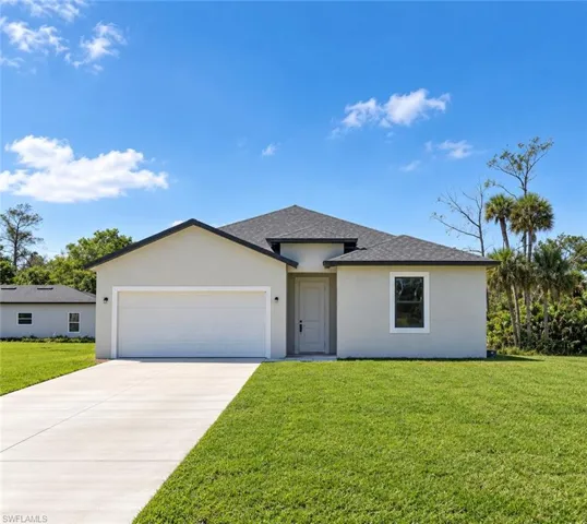 Light gray stucco exterior, dark asphalt shingle roof, attached garage with a white door, concrete driveway, and a manicured green lawn