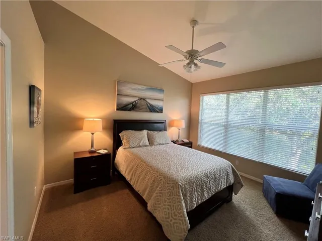 Spacious Primary Bedroom featuring vaulted ceiling and carpet flooring.