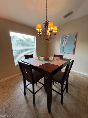Spacious and Bright Dining area with tile floor and volume ceiling.