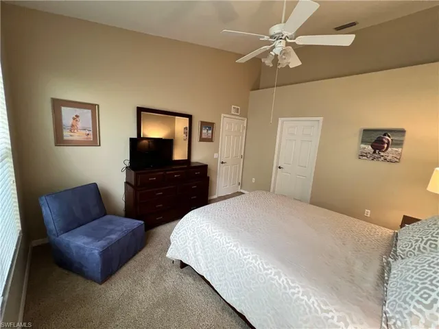 Primary Bedroom featuring carpet floors, volume ceiling and plant shelf.