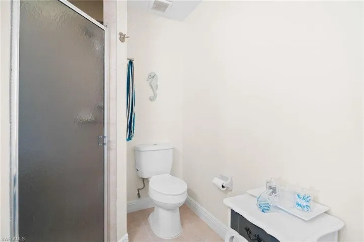 Full bath featuring tile patterned flooring, a shower stall, and vanity