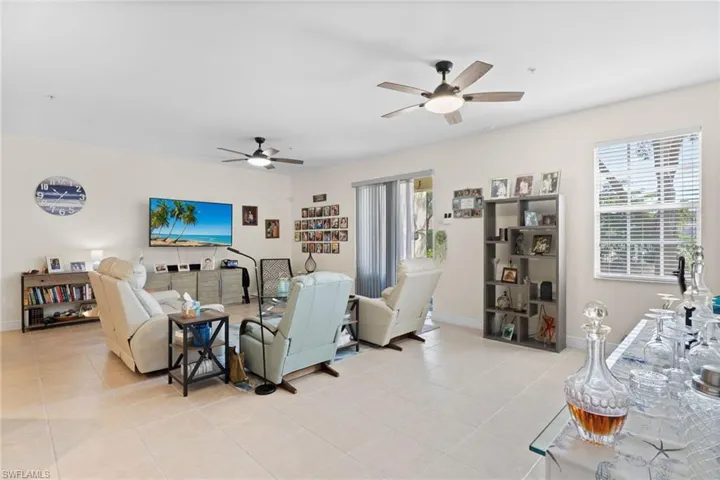 Living area featuring a ceiling fan and light tile patterned floors