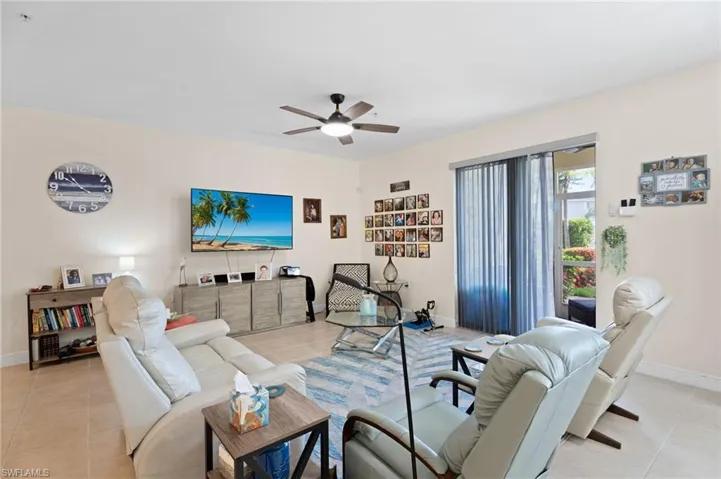 Living room featuring light tile patterned floors and ceiling fan