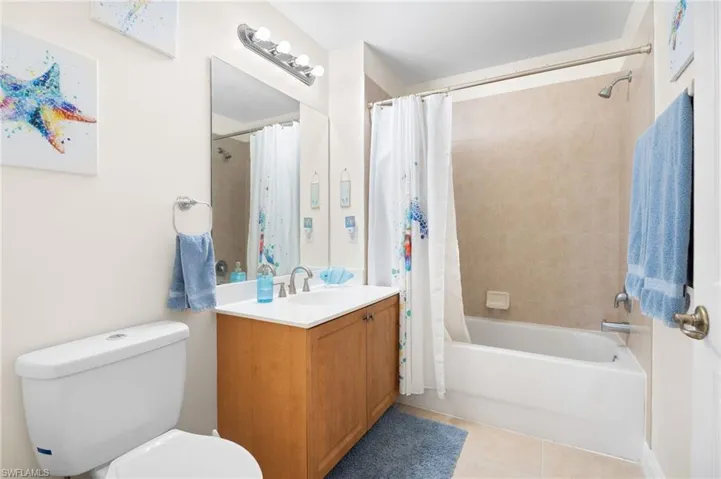 Bathroom featuring tile patterned flooring, vanity, and shower / bath combo with shower curtain
