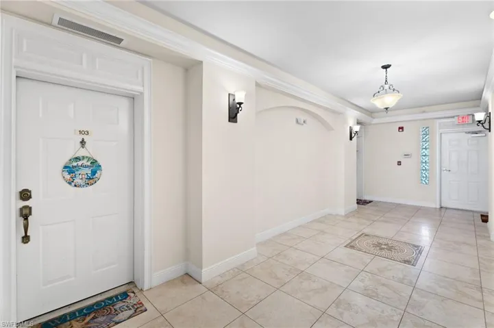Entryway featuring light tile patterned flooring and crown molding