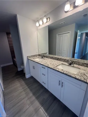 Bathroom with toilet, visible vents, and a sink