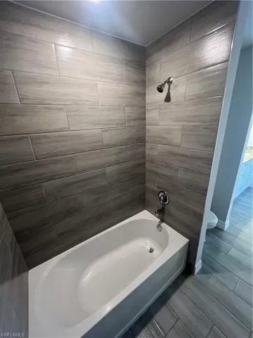 Full bath featuring toilet and bathing tub / shower combination