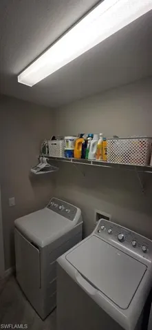 Laundry area with separate washer and dryer and baseboards