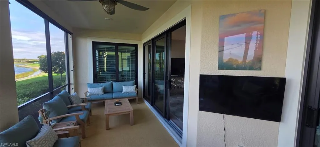 Sunroom featuring a ceiling fan and a water view