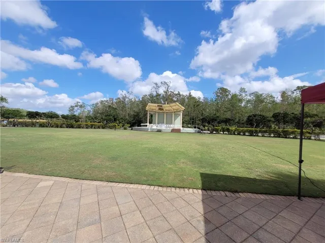 View of green lawn featuring view of scattered trees