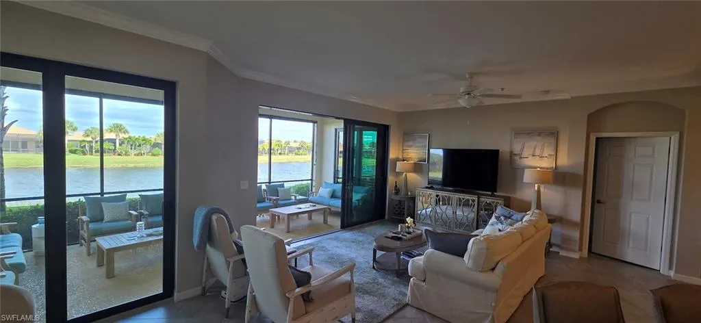 Living area with a ceiling fan and crown molding