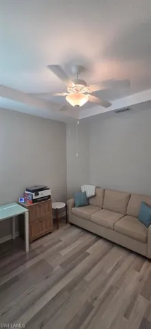 Living area featuring light wood finished floors and a ceiling fan