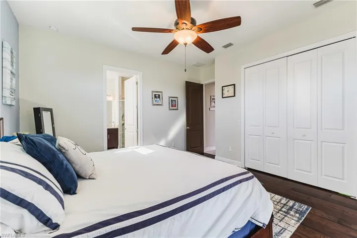 Bedroom featuring dark wood finished floors, a ceiling fan, and a closet