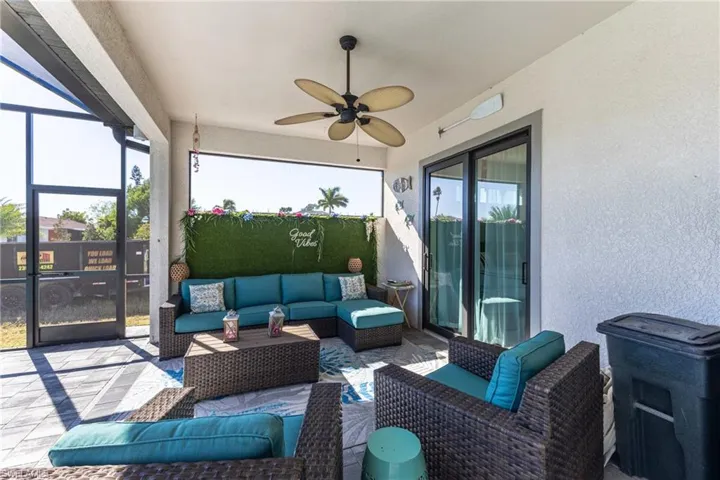 View of patio featuring a ceiling fan, outdoor lounge area, glass enclosure, and a sunroom