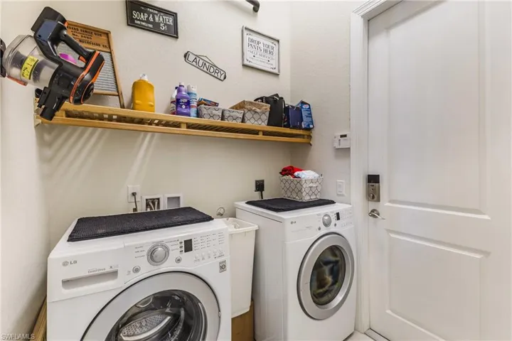 Laundry area featuring separate washer and dryer and a textured wall