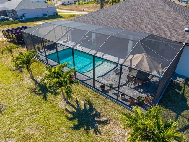 Swimming pool with a sunroom, glass enclosure, and a yard