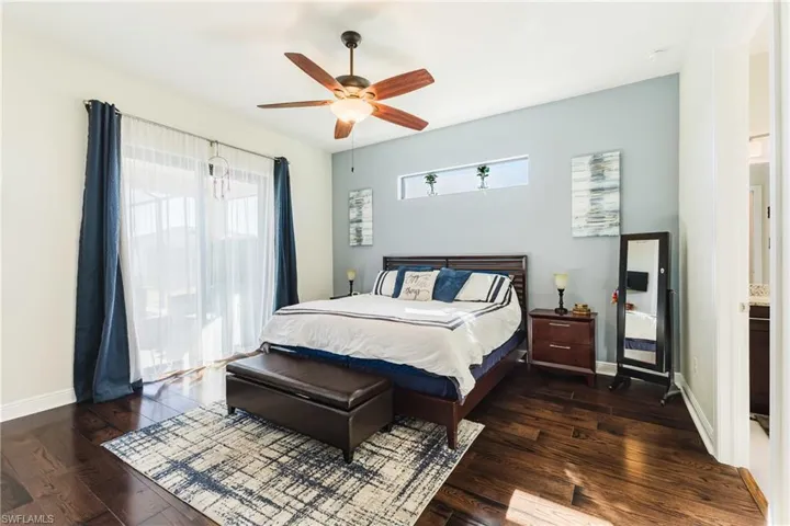 Bedroom with dark wood-type flooring and a ceiling fan