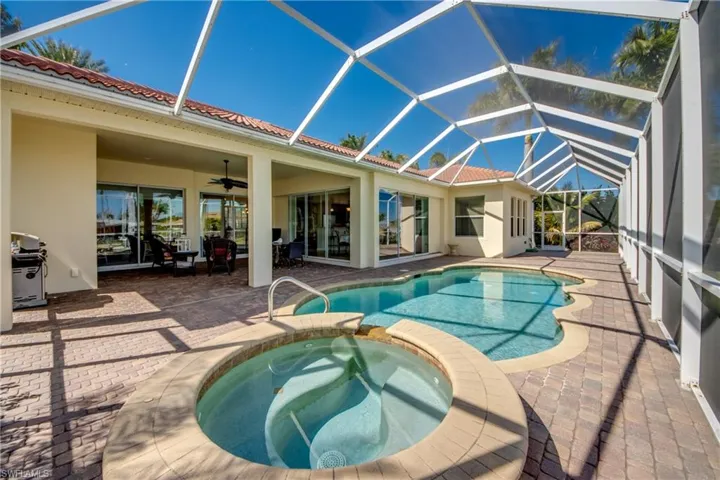 Integrated pool / spa featuring a sunroom, glass enclosure, a patio area, and a grill