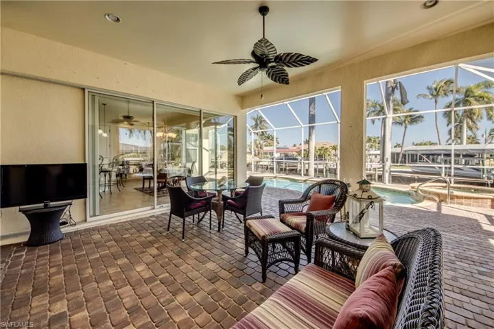 View of patio with a ceiling fan, outdoor lounge area, a lanai, and an outdoor pool