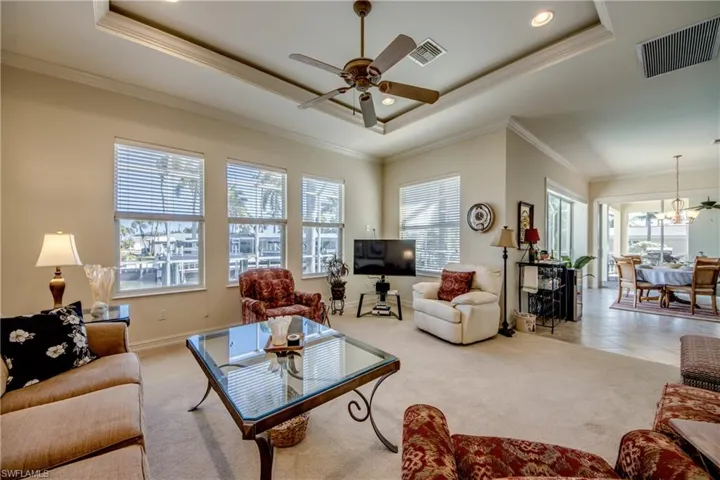 Living room featuring carpet floors, a ceiling fan, crown molding, and recessed lighting