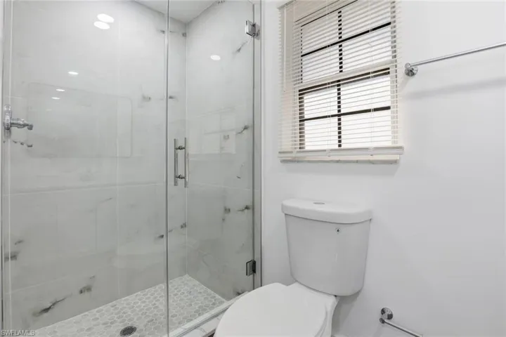 Bathroom featuring toilet and a stall shower