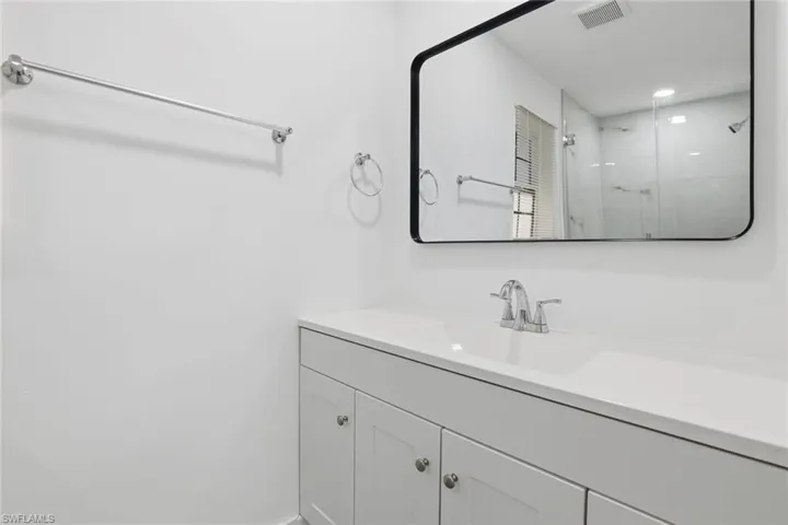 Bathroom with vanity, a shower stall, and recessed lighting