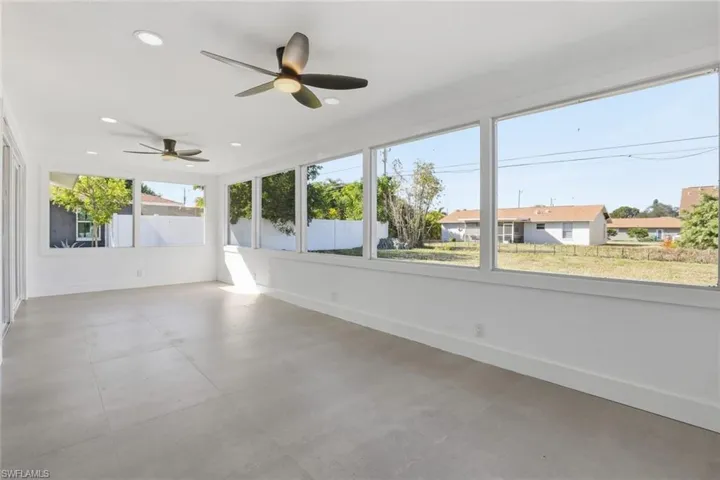 Unfurnished sunroom featuring a ceiling fan