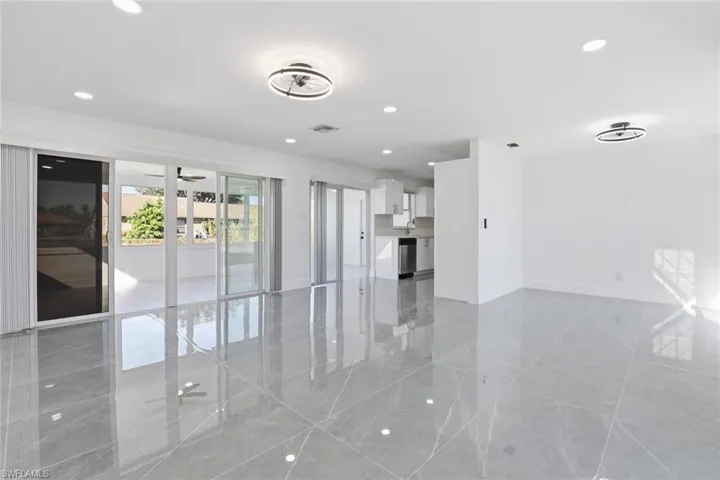 Unfurnished living room with recessed lighting and baseboards