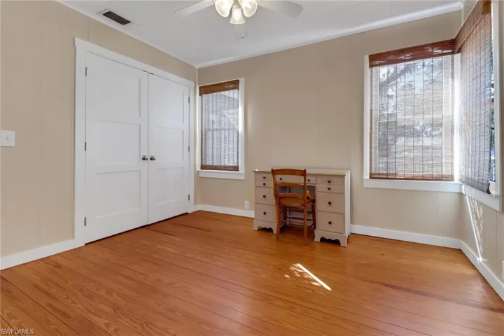 Unfurnished bedroom with multiple windows, light wood-type flooring, and a closet