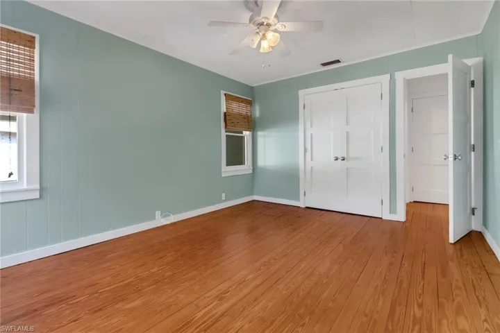 Unfurnished bedroom with ceiling fan, a closet, and light wood-type flooring