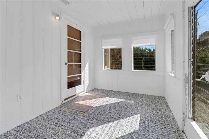 Unfurnished sunroom with wooden ceiling