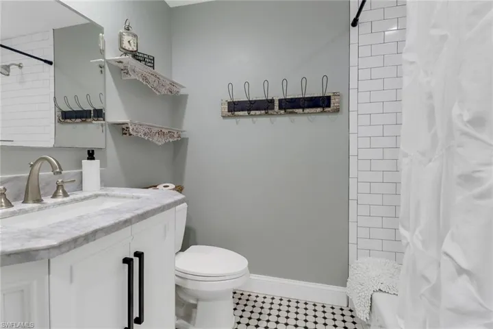 Bathroom with a shower with curtain, vanity, and toilet
