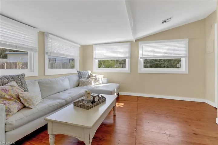 Living room with vaulted ceiling and wood-type flooring