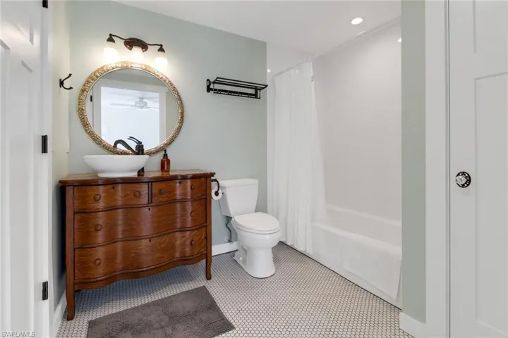Guest House bath with a vanity, and shower / bathtub combination with curtain