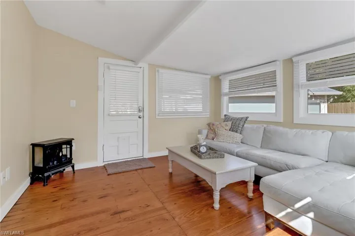 Living room featuring hardwood / wood-style flooring and vaulted ceiling