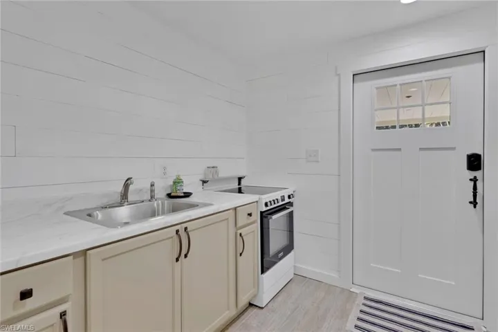 Kitchen featuring electric stove, light wood-style floors, and cream cabinetry