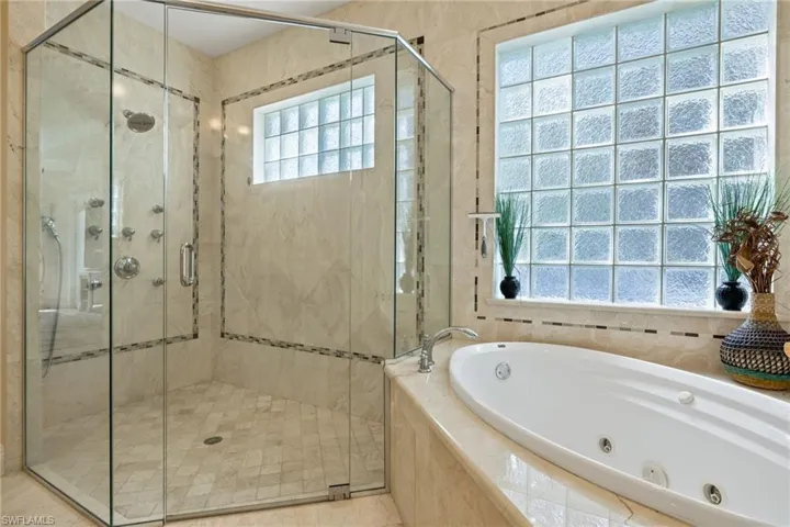 Full bath featuring a jetted tub and a shower stall