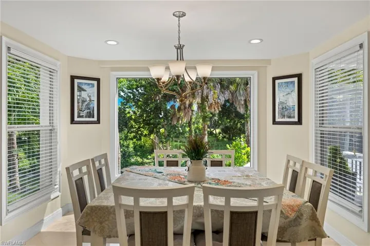 Dining space featuring healthy amount of natural light, a chandelier, recessed lighting, and light tile patterned flooring