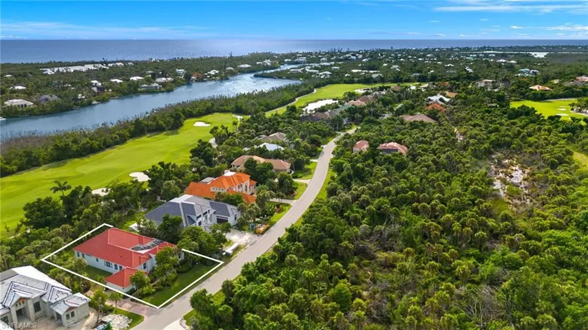 Aerial perspective of suburban area featuring a golf course, a nearby body of water, and property boundaries highlighted
