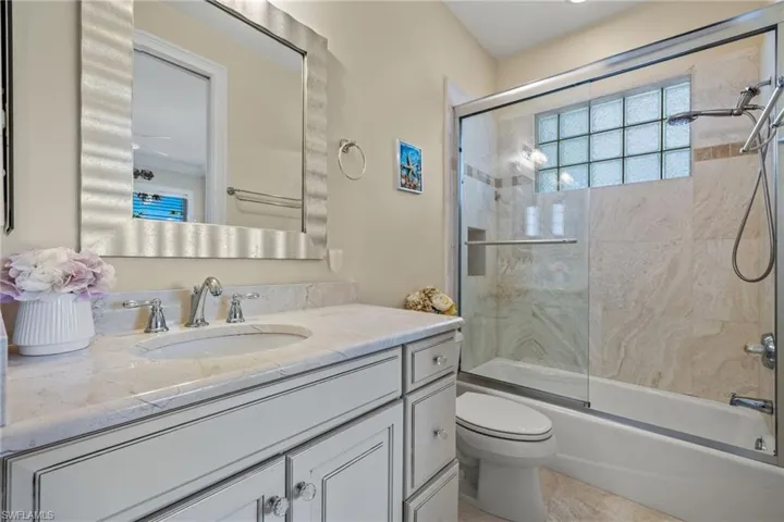 Bathroom featuring enclosed tub / shower combo and vanity