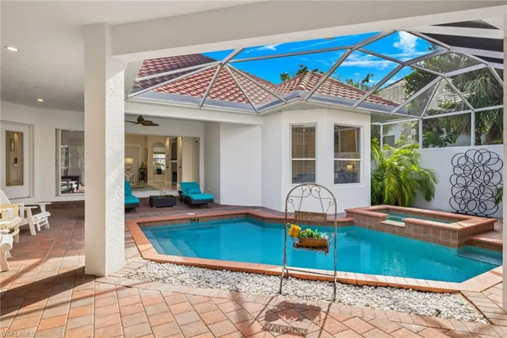 View of swimming pool with a patio, a sunroom, a lanai, a pool with connected hot tub, and ceiling fan