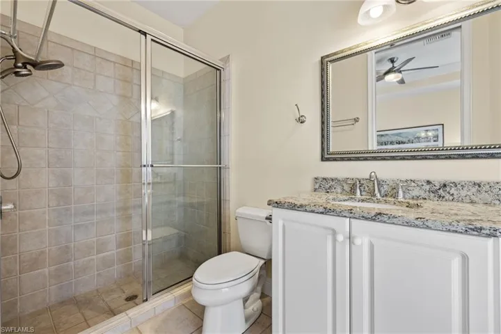 Bathroom with vanity, a stall shower, and light tile patterned flooring