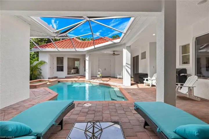 View of swimming pool with a patio area, a ceiling fan, a lanai, a sunroom, and a pool with connected hot tub
